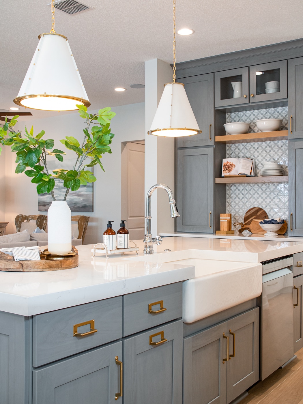 Remodeled kitchen with gray cabinetry and brass hardware by Trenkle Construction