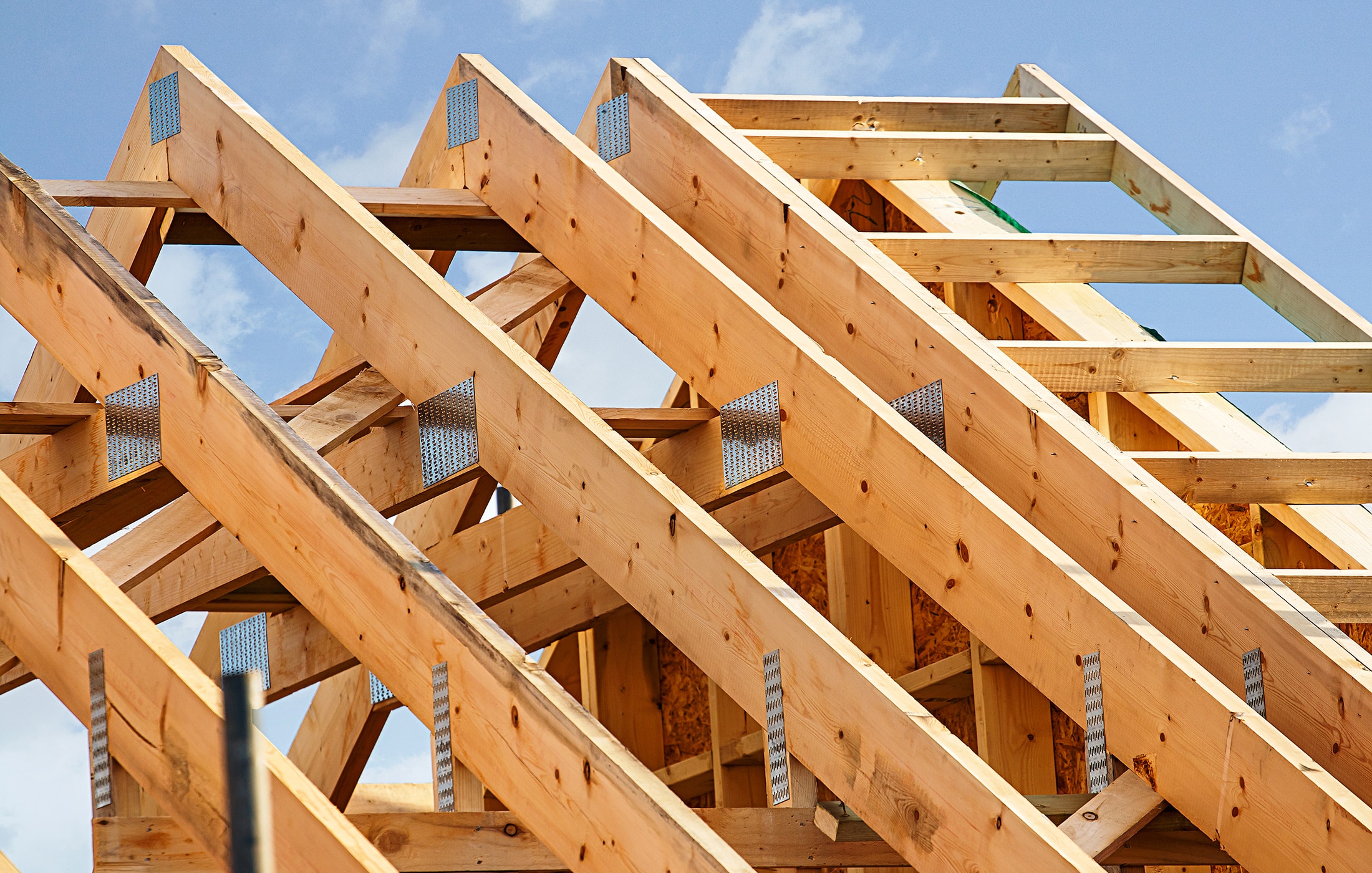 New construction roof trusses framed against a blue South Dakota sky