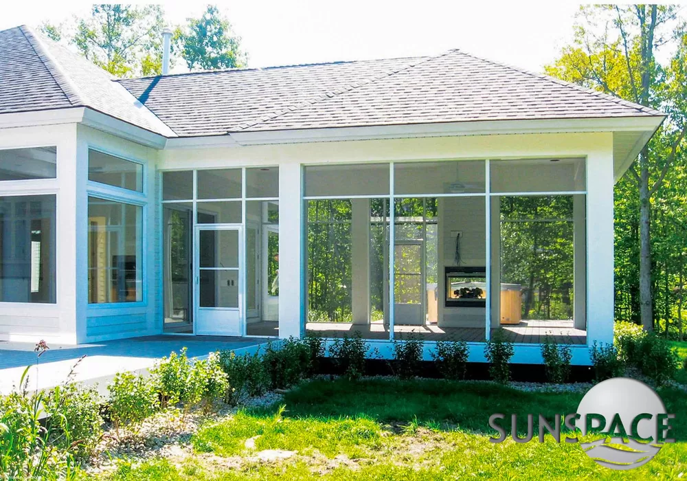Sunspace glass sunroom with an outdoor fireplace and deck