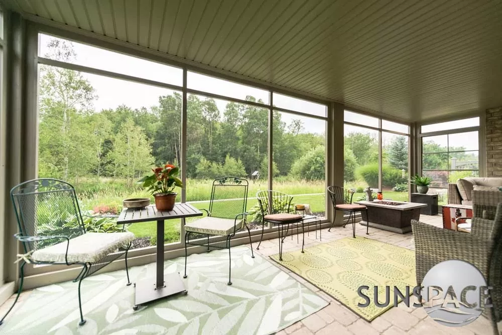 Sunspace screen room with patio furniture and a garden view